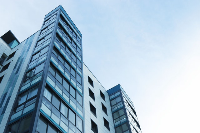 Looking up at tall building with windows and sky in the background