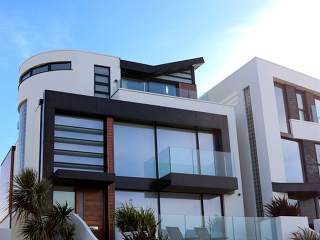 Residential real estate with modern architecture featuring rounded edges with black, glass, and wooden accents