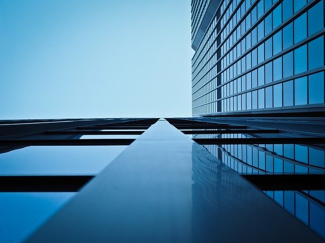 Artistic angle of building looking up from the group at a tall commercial real estate building with windows